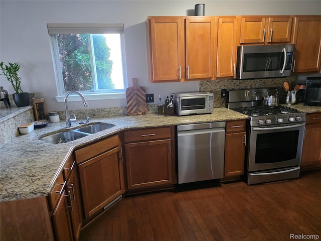 25050 Constitution Ave, Warren, MI 48089 - kitchen with appliances with stainless steel finishes, dark wood-style flooring, light stone countertops, and brown cabinets