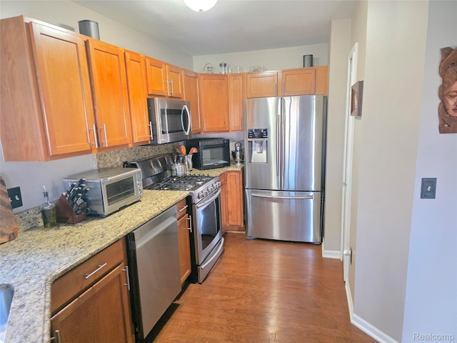 25050 Constitution Ave, Warren, MI 48089 - kitchen featuring stainless steel appliances, wood finished floors, light stone countertops, and brown cabinetry