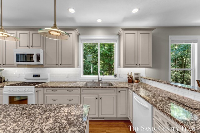13400 Ravine View Dr, Grand Haven, MI 49417 - kitchen with white appliances, backsplash, healthy amount of natural light, dark stone counters, and recessed lighting