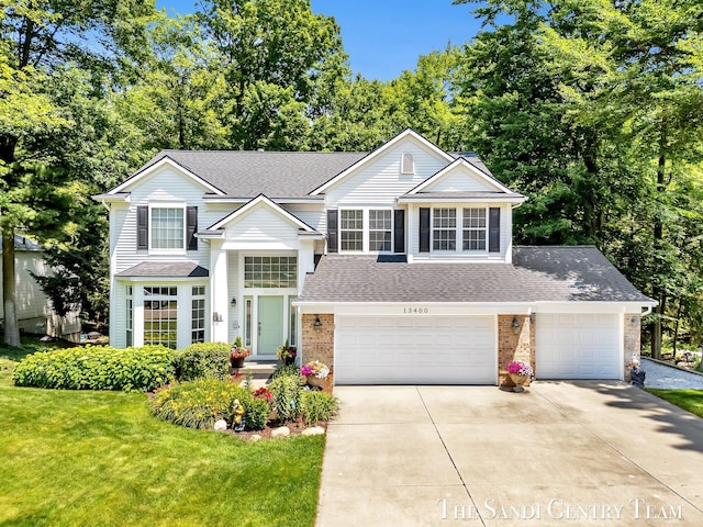 13400 Ravine View Dr, Grand Haven, MI 49417 - traditional-style home featuring roof with shingles, driveway, brick siding, a front yard, and a garage
