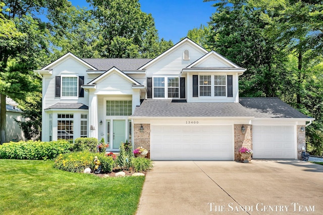 13400 Ravine View Dr, Grand Haven, MI 49417 - traditional-style home featuring concrete driveway, roof with shingles, brick siding, a front lawn, and a garage