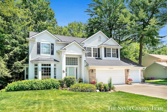 13400 Ravine View Dr, Grand Haven, MI 49417 - traditional-style home with driveway, a front yard, roof with shingles, and an attached garage