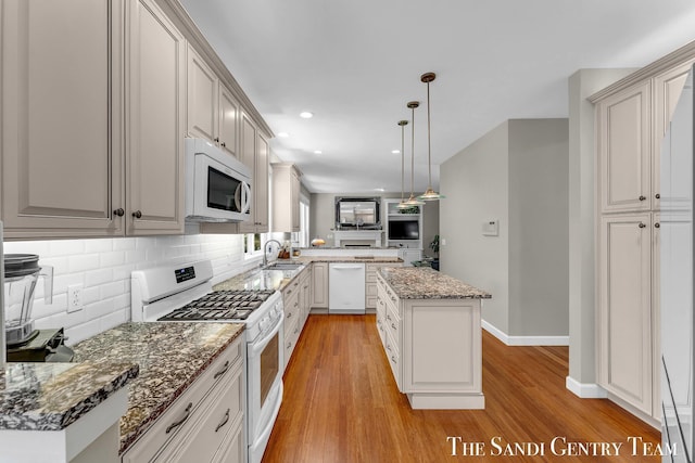 13400 Ravine View Dr, Grand Haven, MI 49417 - kitchen with white appliances, light wood-type flooring, backsplash, a peninsula, and pendant lighting