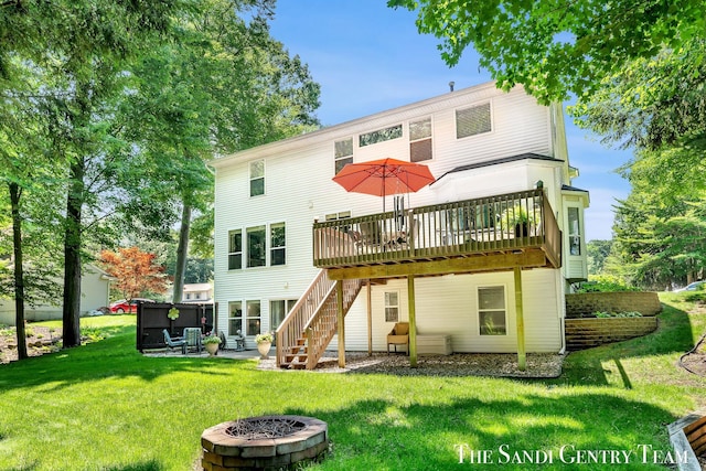 13400 Ravine View Dr, Grand Haven, MI 49417 - back of house featuring an outdoor fire pit, a deck, stairway, and a lawn