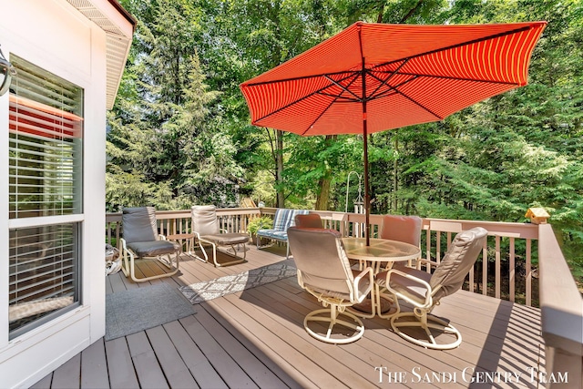 13400 Ravine View Dr, Grand Haven, MI 49417 - deck featuring outdoor dining area and view of wooded area