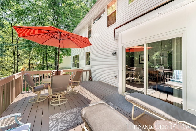 13400 Ravine View Dr, Grand Haven, MI 49417 - wooden deck with outdoor dining area and view of scattered trees