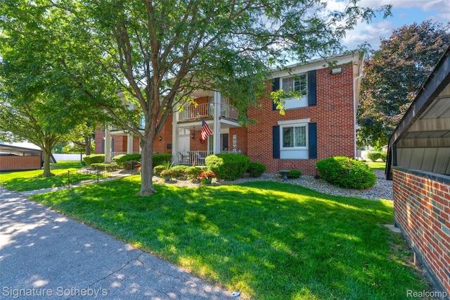 1870 Fort St Unit 1, Trenton, MI 48183 - view of front of home with brick siding, a front lawn, and a balcony