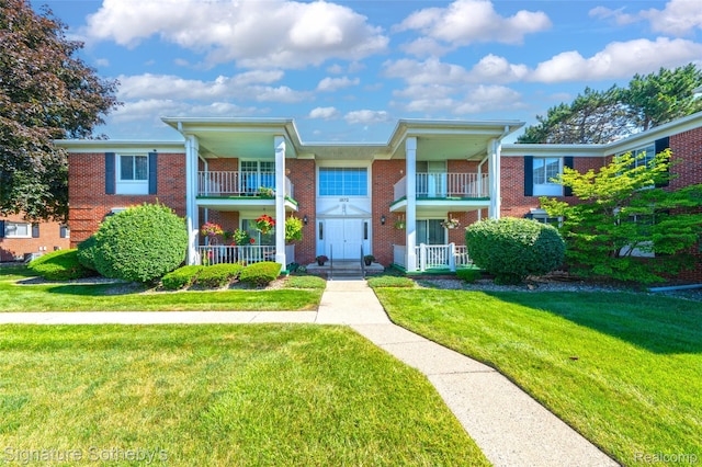 1870 Fort St Unit 1, Trenton, MI 48183 - neoclassical / greek revival house with a balcony, brick siding, and a front yard