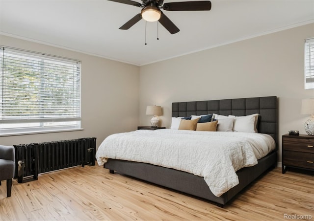 5784 Whittier St, Detroit, MI 48224 - bedroom featuring radiator heating unit, crown molding, multiple windows, and wood finished floors