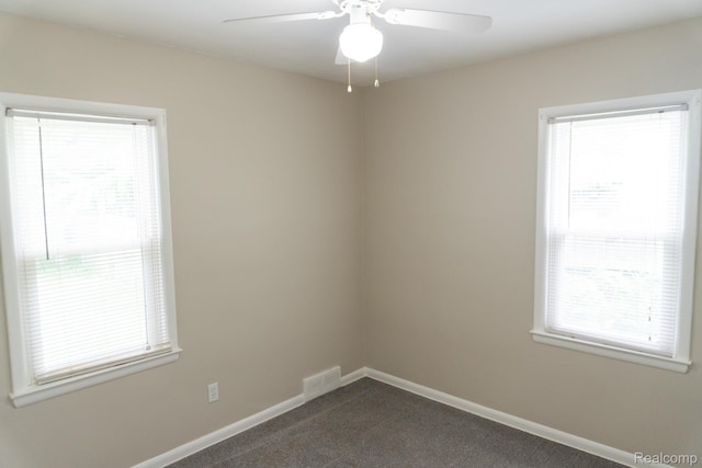 4410 Brunswick Ave, Flint, MI 48507 - spare room featuring dark colored carpet, plenty of natural light, and ceiling fan