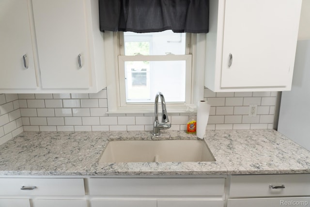 4410 Brunswick Ave, Flint, MI 48507 - kitchen with white cabinetry, decorative backsplash, and light stone counters
