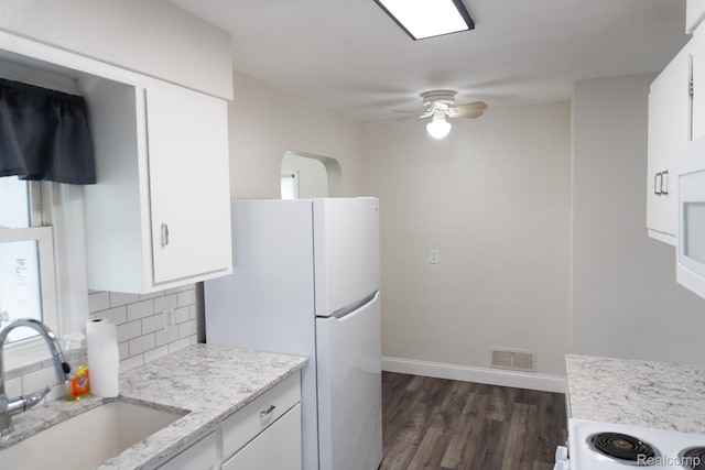 4410 Brunswick Ave, Flint, MI 48507 - kitchen featuring freestanding refrigerator, backsplash, ceiling fan, dark wood-style floors, and white cabinetry