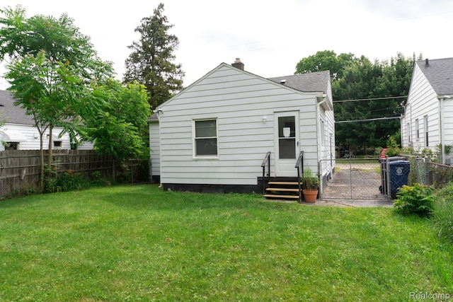 4410 Brunswick Ave, Flint, MI 48507 - rear view of property featuring a chimney, entry steps, and a gate