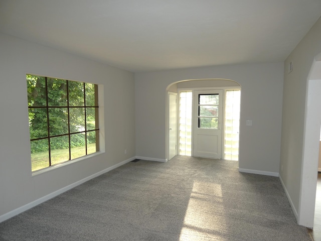 1634 Ogden Ave, Benton Harbor, MI 49022 - carpeted empty room with arched walkways and plenty of natural light