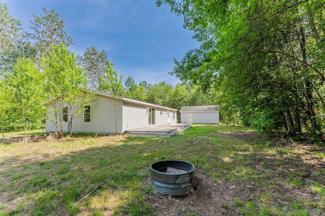 1134 Wagon Wheel Ln, Interlochen, MI 49643 - view of green lawn with a deck and a storage shed