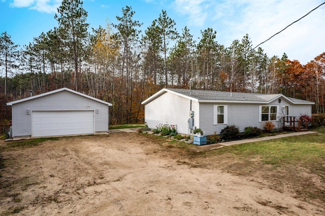 1134 Wagon Wheel Ln, Interlochen, MI 49643 - view of property exterior featuring a detached garage, an outbuilding, and view of scattered trees