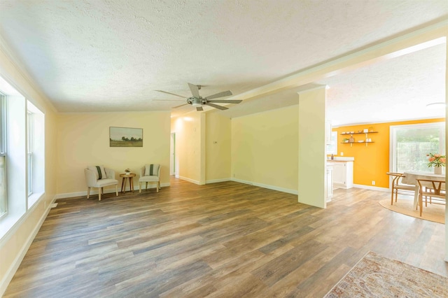 1134 Wagon Wheel Ln, Interlochen, MI 49643 - unfurnished living room with a textured ceiling, wood finished floors, and ceiling fan