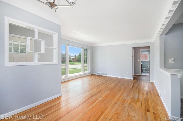 2890 Maxwell St, Trenton, MI 48183 - empty room featuring light wood-style floors and a chandelier