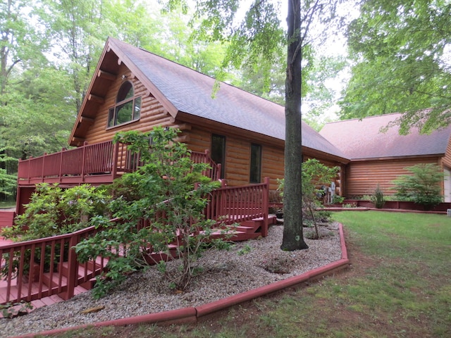 6325 Big Bay Rd, Bear Lake, MI 49614 - view of home's exterior featuring a deck, log siding, a shingled roof, and a yard