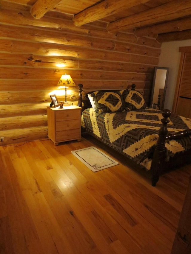6325 Big Bay Rd, Bear Lake, MI 49614 - bedroom with log walls, light wood finished floors, and beamed ceiling