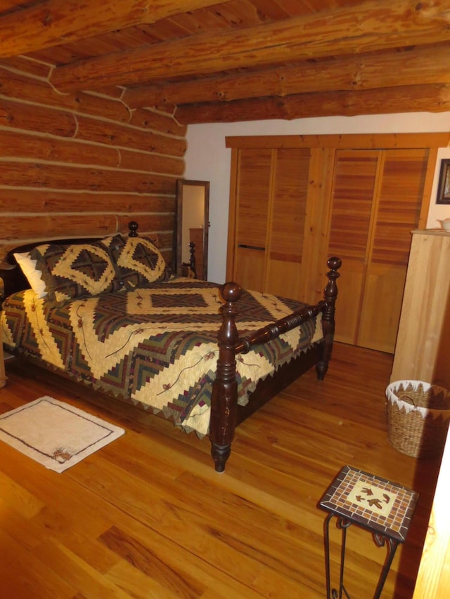 6325 Big Bay Rd, Bear Lake, MI 49614 - bedroom featuring wood finished floors, beamed ceiling, and rustic walls