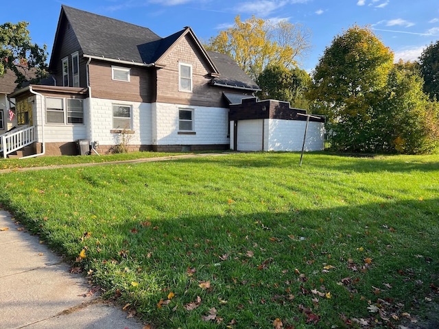 611 Steward Ave, Jackson, MI 49202 - view of home's exterior featuring a lawn, an attached garage, and a shingled roof