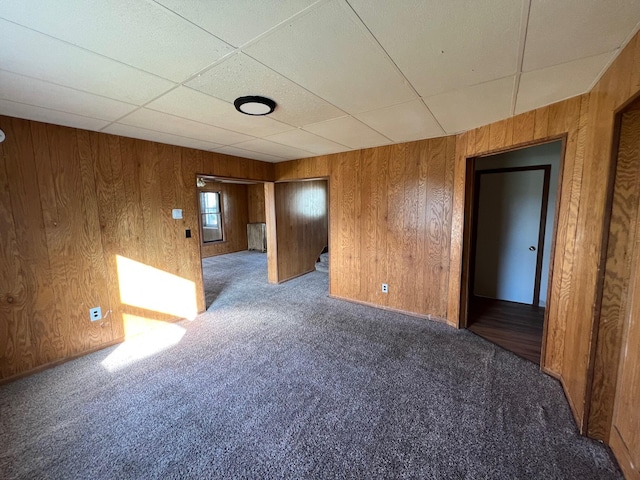 611 Steward Ave, Jackson, MI 49202 - carpeted empty room with a paneled ceiling and wood walls