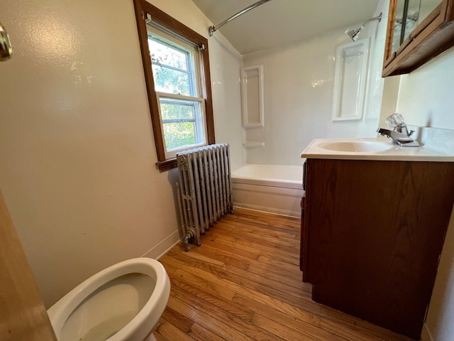 611 Steward Ave, Jackson, MI 49202 - full bathroom with radiator, vanity, shower / bathtub combination, and wood finished floors