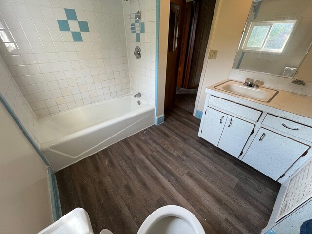 611 Steward Ave, Jackson, MI 49202 - full bath featuring wood finished floors, vanity, and tub / shower combination
