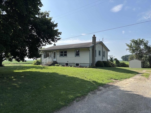 6143 Shepherd Rd, Adrian, MI 49221 - view of front facade featuring a chimney, a front lawn, and a shed