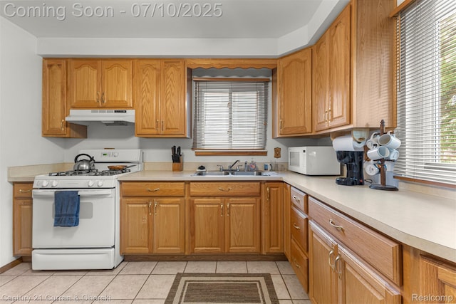 25416 Yale St S, Dearborn Heights, MI 48125 - kitchen featuring white appliances, under cabinet range hood, light countertops, light tile patterned flooring, and brown cabinetry