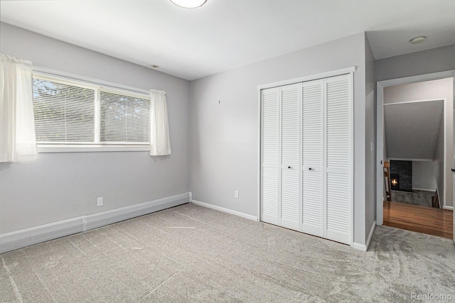 2145 Helmsford Dr, Wolverine Lake, MI 48390 - unfurnished bedroom with carpet floors, a closet, and a lit fireplace