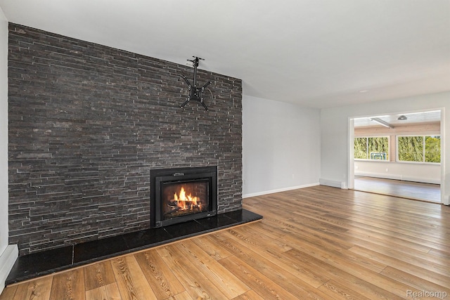 2145 Helmsford Dr, Wolverine Lake, MI 48390 - unfurnished living room with hardwood / wood-style floors and a glass covered fireplace