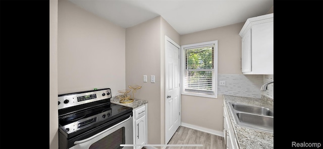 19704 Saint Aubin St, Detroit, MI 48234 - kitchen featuring stainless steel electric range, light wood finished floors, white cabinets, light countertops, and tasteful backsplash