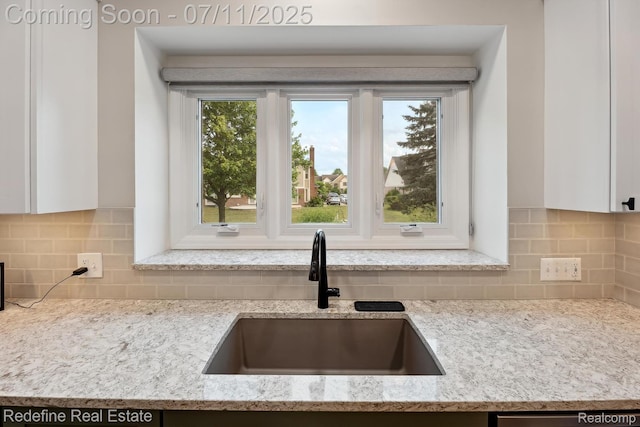 47451 Wallingford Ct, Canton, MI 48188 - kitchen with white cabinetry, backsplash, light stone countertops, and stainless steel dishwasher