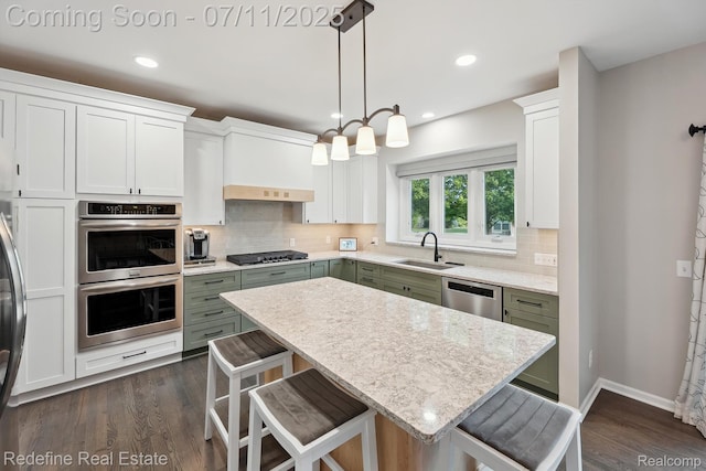 47451 Wallingford Ct, Canton, MI 48188 - kitchen featuring stainless steel appliances, a kitchen breakfast bar, decorative backsplash, dark wood-type flooring, and recessed lighting