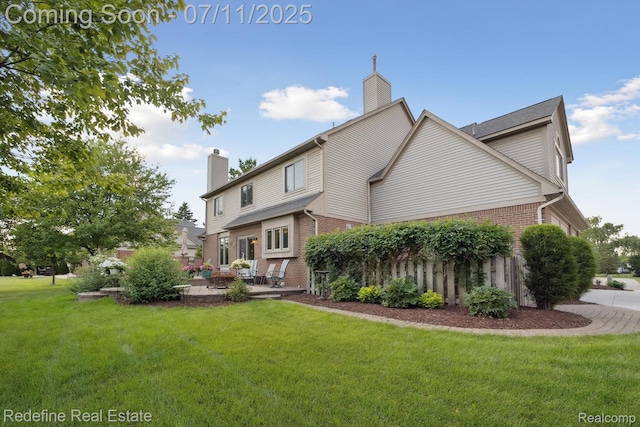 47451 Wallingford Ct, Canton, MI 48188 - rear view of property with brick siding, a chimney, a lawn, and a patio