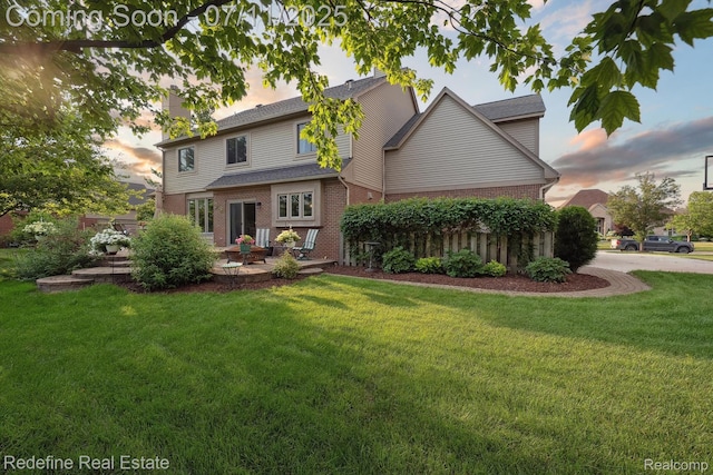 47451 Wallingford Ct, Canton, MI 48188 - view of front of property with brick siding, a yard, a patio, and a chimney