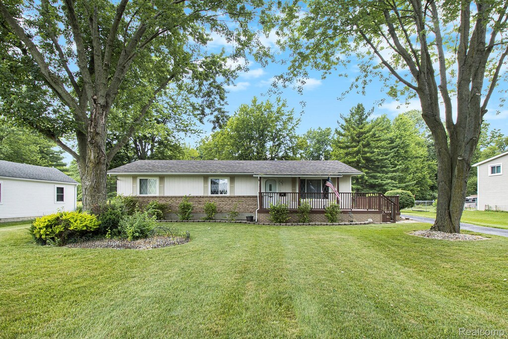2100 Carleton W Rd, Carleton, MI 48117 - ranch-style home with brick siding, a front yard, a shingled roof, and covered porch