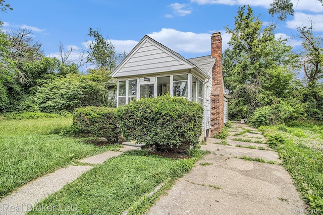 13576 Warwick St, Detroit, MI 48223 - view of front of property with a chimney and a sunroom