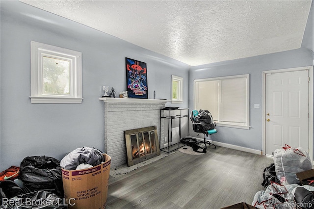 13576 Warwick St, Detroit, MI 48223 - living area with a brick fireplace, a textured ceiling, wood finished floors, and healthy amount of natural light