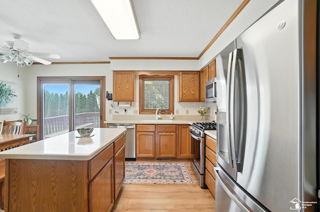 7369 Apple Grove Ln, Temperance, MI 48182 - kitchen with appliances with stainless steel finishes, brown cabinets, light wood-style floors, light countertops, and ornamental molding