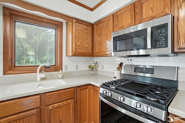 7369 Apple Grove Ln, Temperance, MI 48182 - kitchen featuring stainless steel appliances, tasteful backsplash, light countertops, crown molding, and brown cabinets