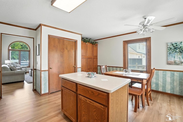 7369 Apple Grove Ln, Temperance, MI 48182 - kitchen featuring light wood-type flooring, light countertops, ornamental molding, a ceiling fan, and a center island