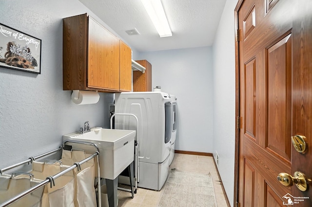 7369 Apple Grove Ln, Temperance, MI 48182 - washroom with cabinet space, washer and clothes dryer, light tile patterned flooring, a textured ceiling, and a textured wall