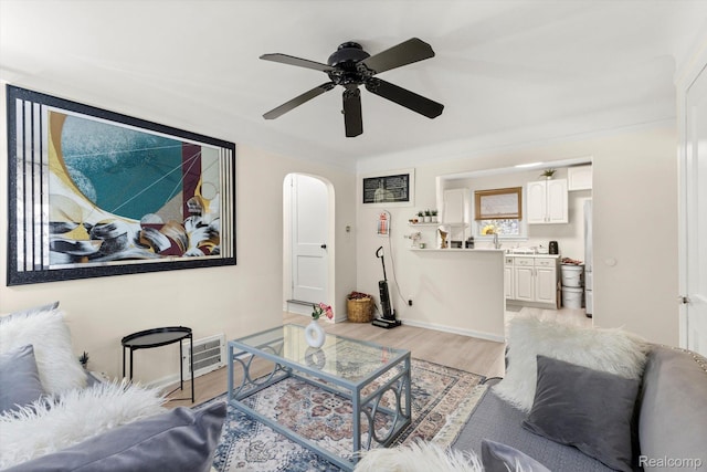 18291 Henry St, Melvindale, MI 48122 - living area featuring light wood-style flooring, a ceiling fan, and arched walkways