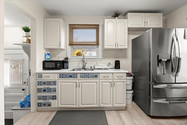 18291 Henry St, Melvindale, MI 48122 - kitchen featuring stainless steel fridge with ice dispenser, black microwave, light wood-style floors, and white cabinets