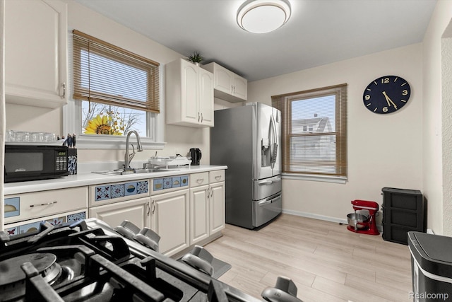 18291 Henry St, Melvindale, MI 48122 - kitchen featuring stainless steel fridge with ice dispenser, black microwave, white cabinetry, and healthy amount of natural light