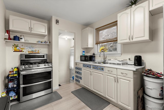 18291 Henry St, Melvindale, MI 48122 - kitchen with double oven range, white cabinets, light countertops, and light wood-style floors