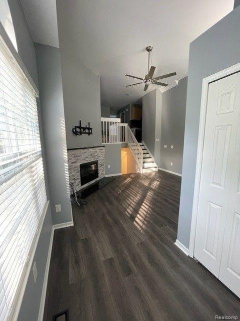 1530 Maryland Club Dr, Royal Oak, MI 48067 - unfurnished living room featuring a ceiling fan, a fireplace, wood finished floors, and stairs